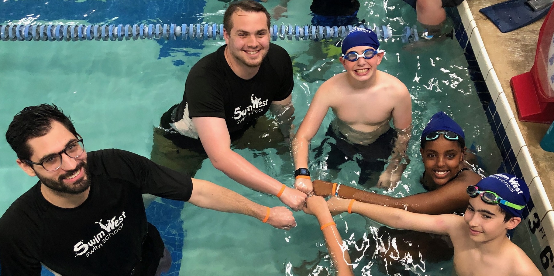 Counselor giving a camper a fist bump during swim time