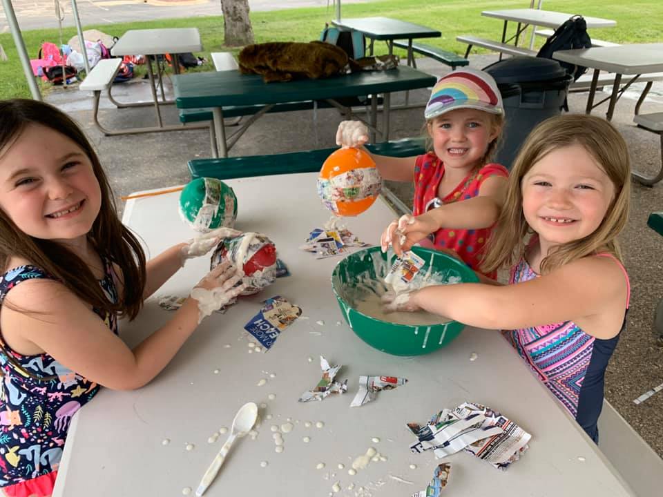 Campers painting and making crafts at the craft table