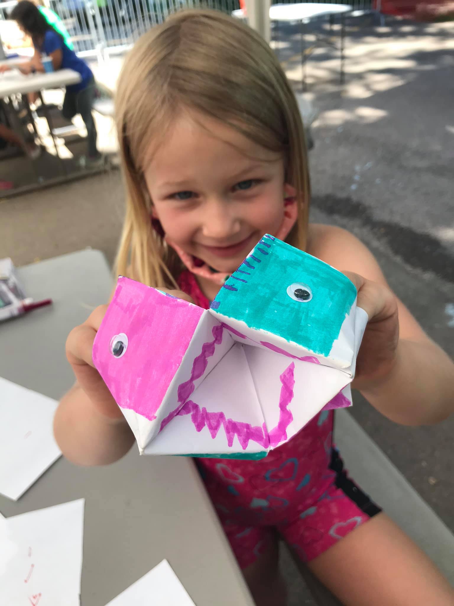 Camper holding up a painted craft project