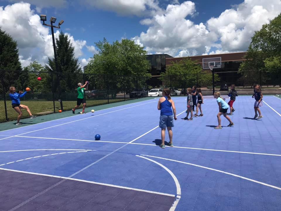 Campers playing a game together on the outdoor sports court