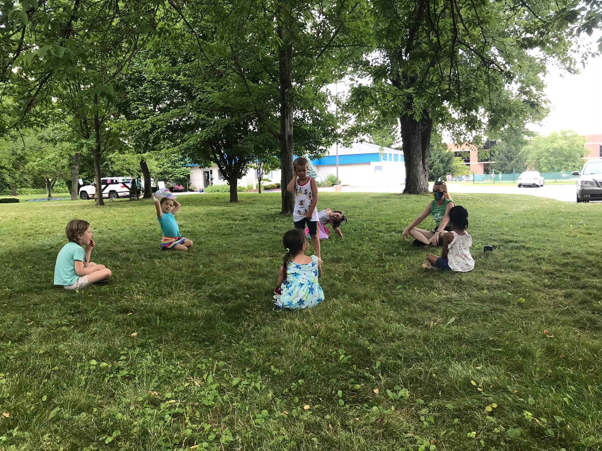 Campers relaxing and playing on the grass field