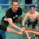Counselor giving a camper a fist bump during swim time