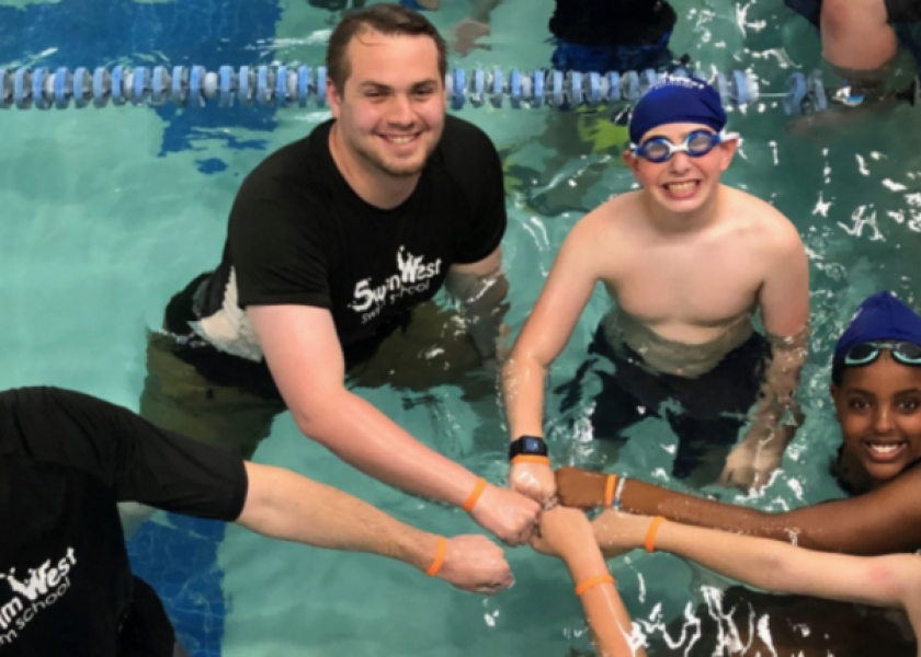Counselor giving a camper a fist bump during swim time