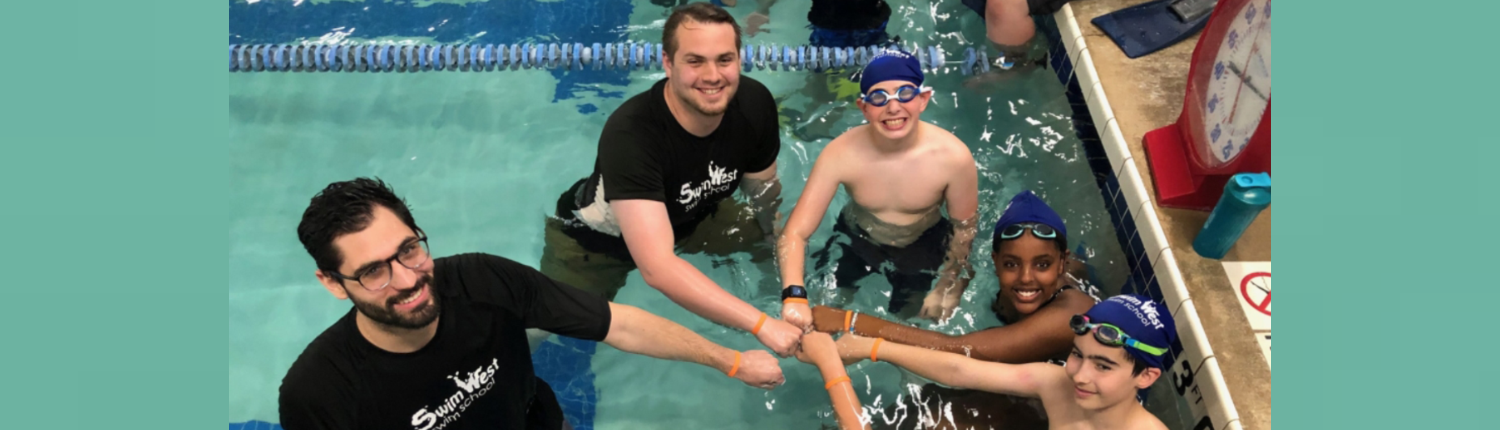 Counselor giving a camper a fist bump during swim time