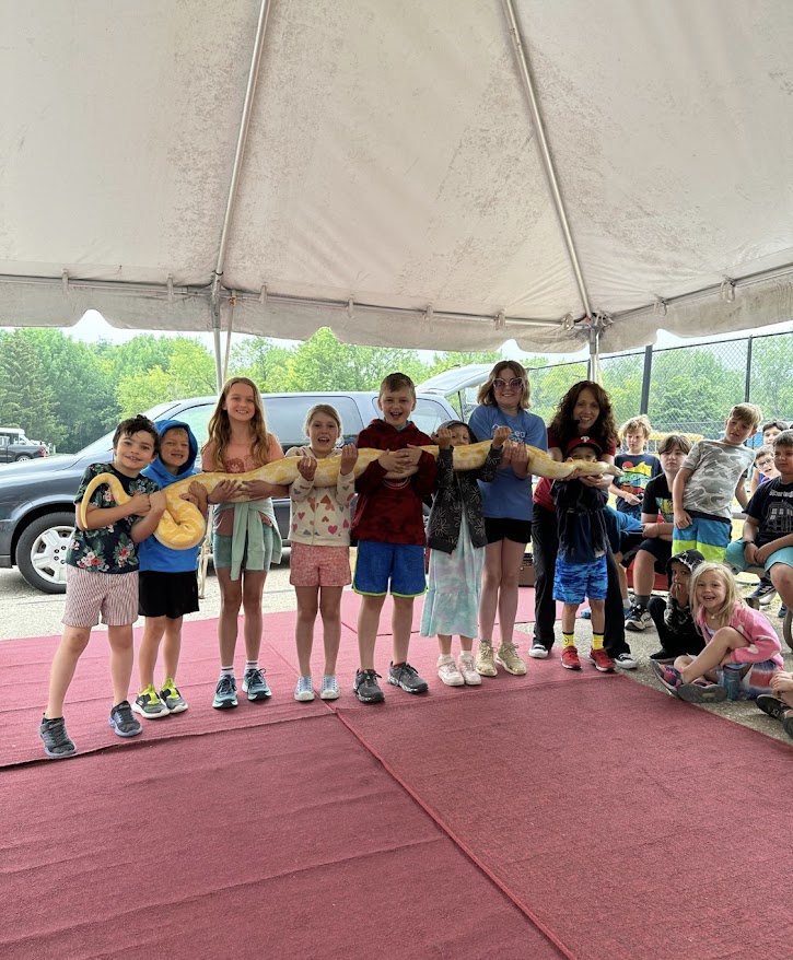 Campers lined up under the tent for a visiting animal presentation