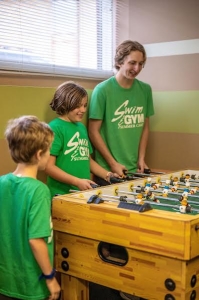Campers playing foosball indoors at camp