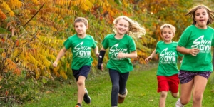 Campers in Swim&Gym t-shirts running outdoors together