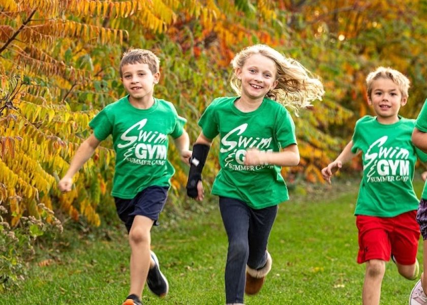 Campers in Swim&Gym t-shirts running outdoors together